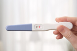 Pregnancy,Test,In,Female,Hand,On,Blurred,Background